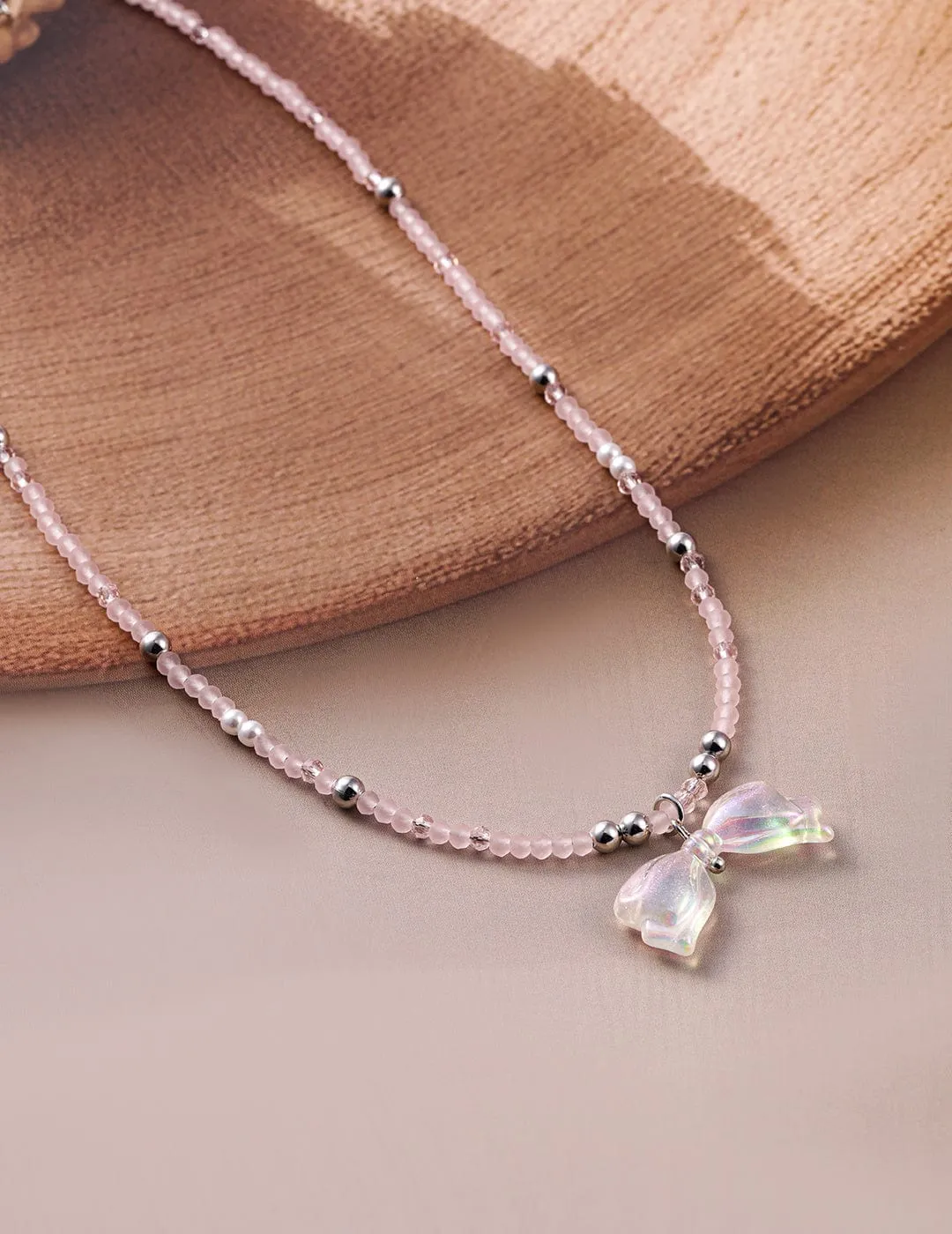 Rhodium Plated Pink Beaded Necklace with Iridescent Butterfly Bow Pendant